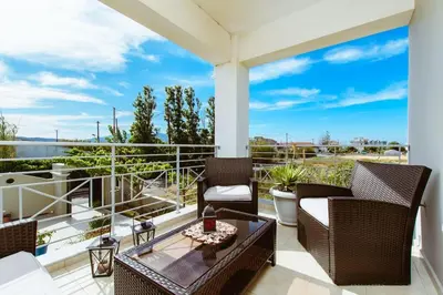 a patio with chairs and a table on a balcony at Suite Erato in Kissamos