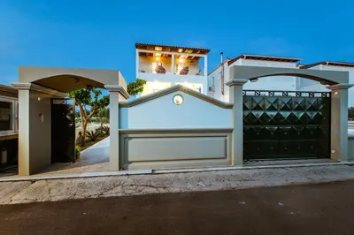 a white garage with a black gate in front of a house at Suite Erato in Kissamos