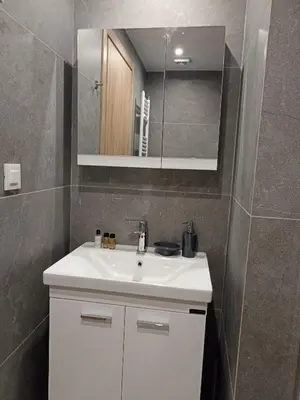 a bathroom with a white sink and a mirror at Alchania komi luxury apartment in Chania Town