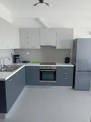 a kitchen with white cabinets and a stainless steel refrigerator at Alchania komi luxury apartment in Chania Town