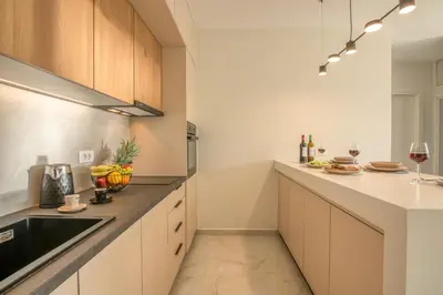 a kitchen with white cabinets and a sink at Villenia Luxury Apartments in Kissamos