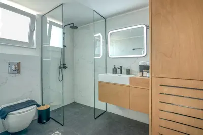 a bathroom with a shower and a sink and a toilet at Villenia Luxury Apartments in Kissamos