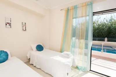 a bedroom with two beds and a window at Kronos Villas in Kolymvari