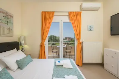 a bedroom with a bed with orange curtains and a balcony at AnnaBoutique Villa Next to Beach Private Pool & BBQ in Kato Daratso