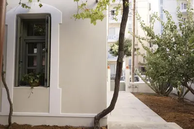 a white house with a black door and trees at Villa Kalliopi in Chania Town
