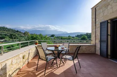 a patio with a table and chairs on a balcony at Villas Kalives in Kalyves