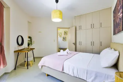 a bedroom with a large bed with a pink blanket at Lazareta 3 in Chania Town