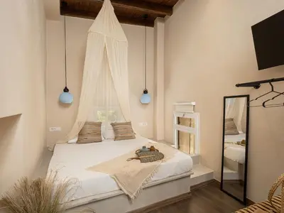 a bedroom with a large white bed with a mirror at Artemide city places _Leon tiny suite in Chania Town