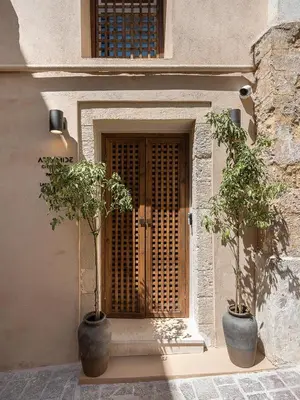 two potted trees sitting in front of a door at Artemide city places _Leon tiny suite in Chania Town