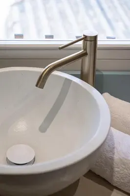 a white sink with a faucet in front of a window at Artemide city places _Leon tiny suite in Chania Town