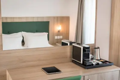 a hotel room with a bed and a desk with a television at Glykeria Hotel in Elafonisi