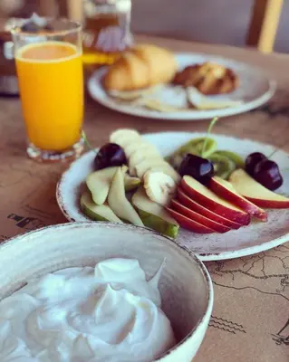 a table with plates of food and a bowl of dip at Glykeria Hotel in Elafonisi