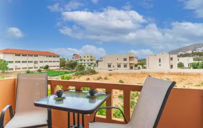a table and chairs on a balcony with a view at Kaiti 's Studios & Apartments in Palaiochóra