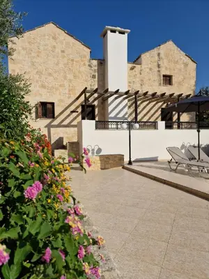 a patio with flowers in front of a building at Villa Penelope Luxury Retreat with Pool & Timeless Charm in Douliana