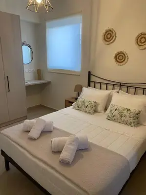 a large white bed with two towels on it at Thalassa Grammeno seaview house in Palaiochóra