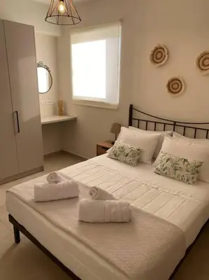 a bedroom with a large white bed with towels on it at Thalassa Grammeno seaview house in Palaiochóra