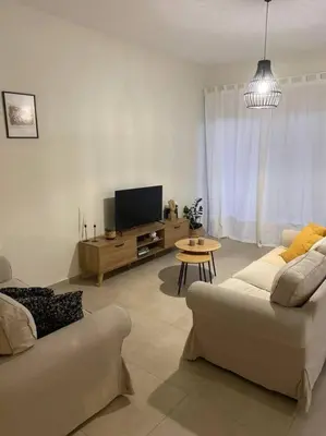 a living room with a couch and a tv at Thalassa Grammeno seaview house in Palaiochóra