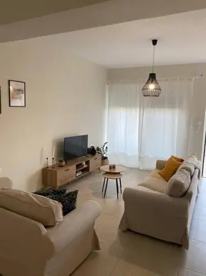 a living room with two couches and a tv at Thalassa Grammeno seaview house in Palaiochóra
