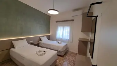 a small room with two beds and a window at Downtown Delight in Chania Town