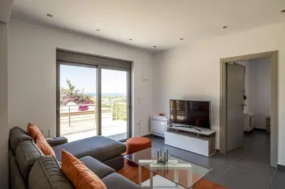 a living room with a couch and a tv at Kayzo Luxury Apartment With Pool in Tavronitis