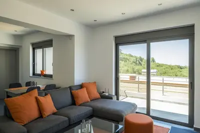 a living room with a couch and a large window at Kayzo Luxury Apartment With Pool in Tavronitis