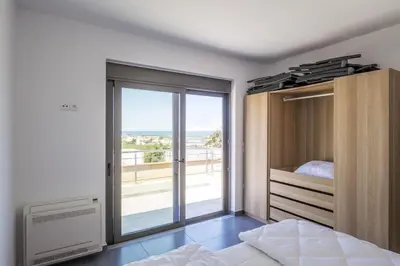 a bedroom with a bed and a sliding glass door at Kayzo Luxury Apartment With Pool in Tavronitis