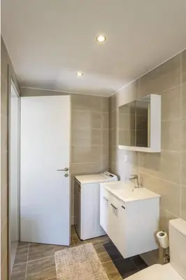 a bathroom with a white sink and a toilet at Kayzo Luxury Apartment With Pool in Tavronitis