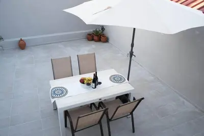 a white table and chairs with an umbrella at Myra city House in Chania Town