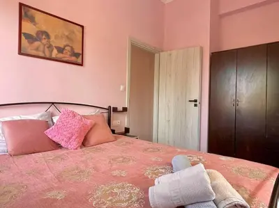 a bedroom with a large bed with pink walls at Souda Bay in Souda