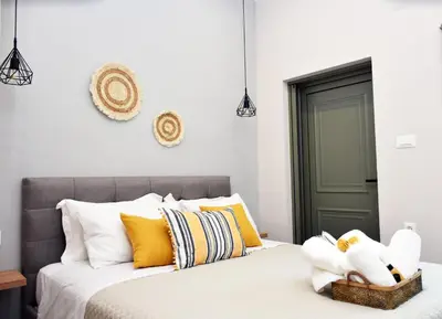 a bedroom with a bed with yellow and white pillows at Manolis cozy home in Chania Town