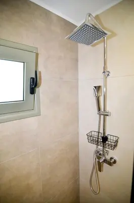 a shower with a window and a shower head at Manolis cozy home in Chania Town