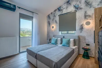 a bedroom with a large bed with a large window at Alyona Villas - Villa Lona in Skinés
