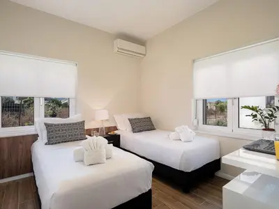 two beds in a room with two windows at HappyHouse Villa in Kissamos