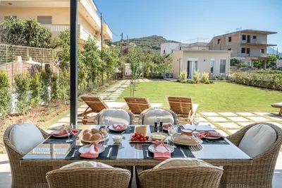 a table with chairs and food on top of it at HappyHouse Villa in Kissamos