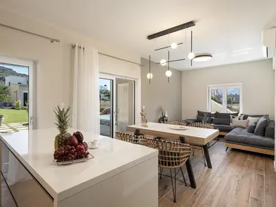 a kitchen and living room with a table and chairs at HappyHouse Villa in Kissamos