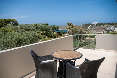 a patio with a table and chairs on a balcony at Mediterranean villa Seaview privet pool in Tersanas
