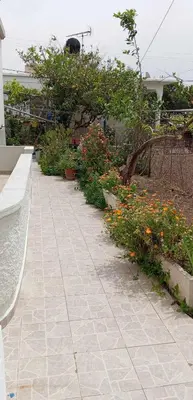 a walkway with flowers and a bench in a garden at Maria's sala in Kissamos