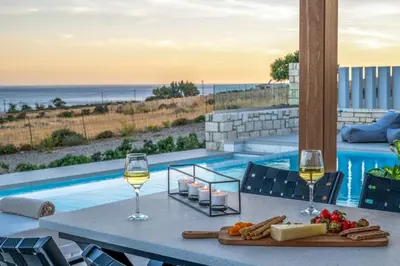 a table with two glasses of wine and a tray of food at FYSIOPHYLIA VILLAS in Frangokastello