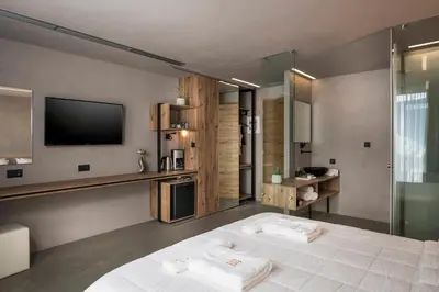 a hotel room with a bed and a television at Icarus Hotel in Kalamaki Chanion
