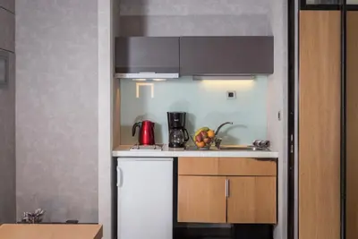 a small kitchen with a sink and a microwave at Icarus Hotel in Kalamaki Chanion