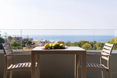 a table with a bowl of fruit on top of a balcony at Heliades Residence in Kounoupidhianá