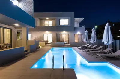 a villa with a swimming pool at night at Heliades Residence in Kounoupidhianá