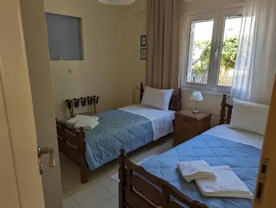 a bedroom with two beds and a tv and a window at ALMA central apartment in Chania Town