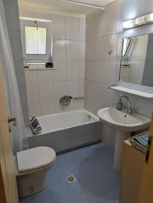 a bathroom with a tub and a toilet and a sink at ALMA central apartment in Chania Town