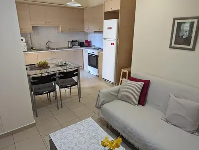 a living room with a couch and a kitchen at ALMA central apartment in Chania Town