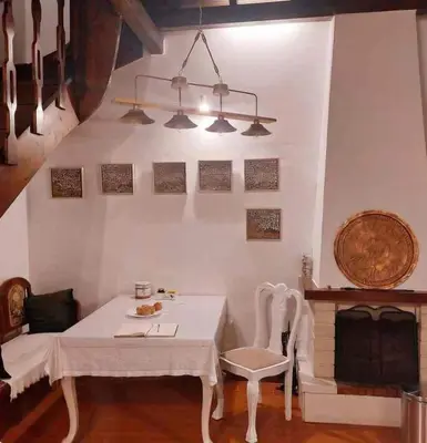 a dining room with a table and a fireplace at Myron House in Chania Town