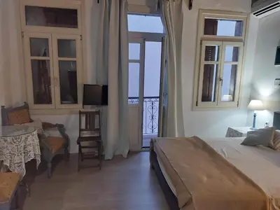 a bedroom with a bed and a table and a television at Myron House in Chania Town