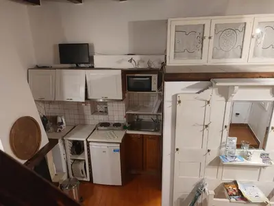 a small kitchen with white cabinets and a white refrigerator at Myron House in Chania Town