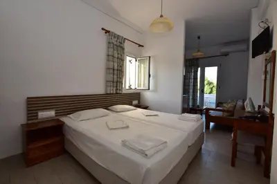 a bedroom with a large white bed in a room at Morpheas Rooms in Palaiochóra
