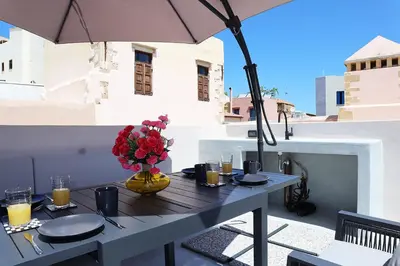 a table with a vase of flowers on a balcony at Porto 57 in Chania Town